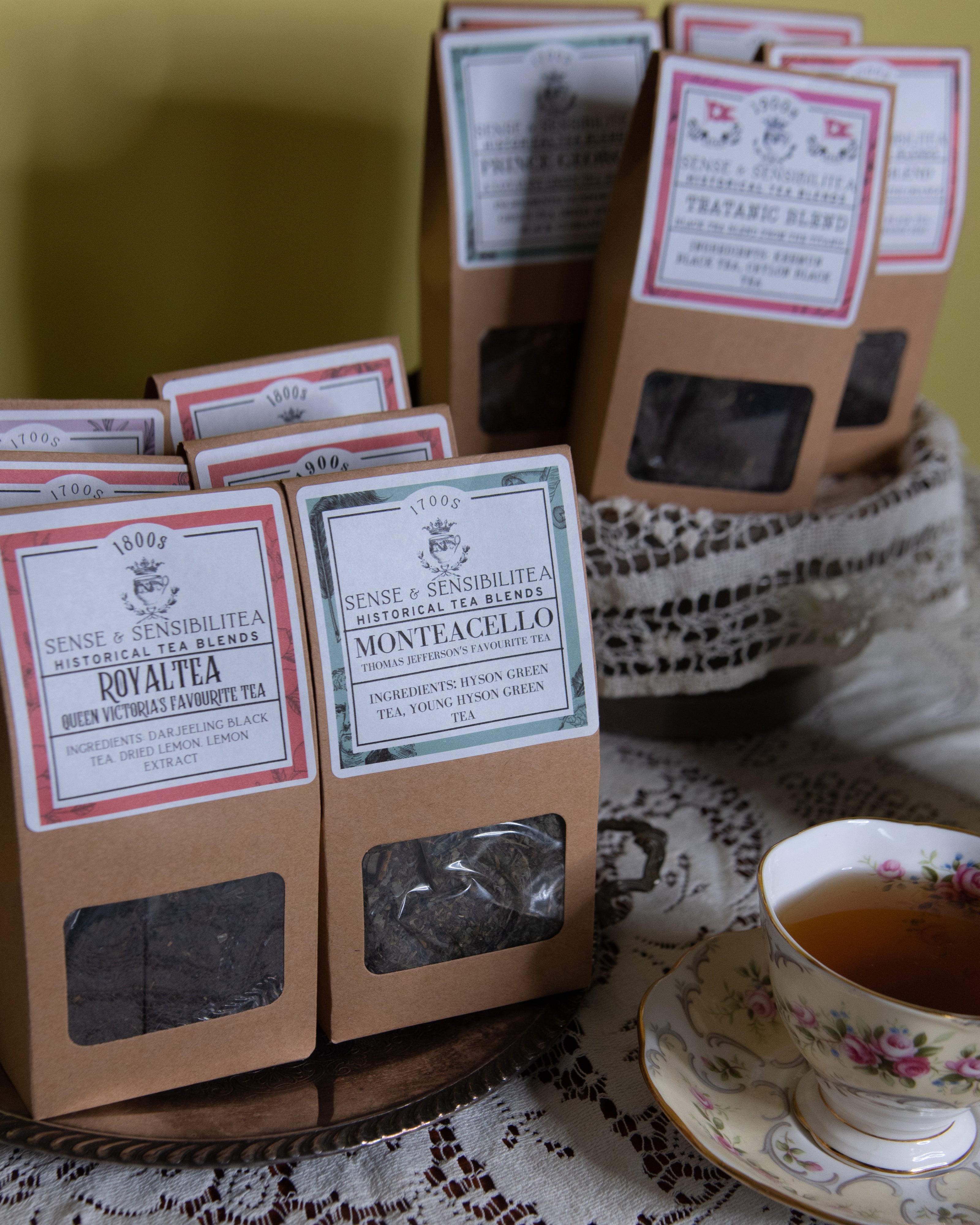 Packed tea blends displayed next to a cup of tea