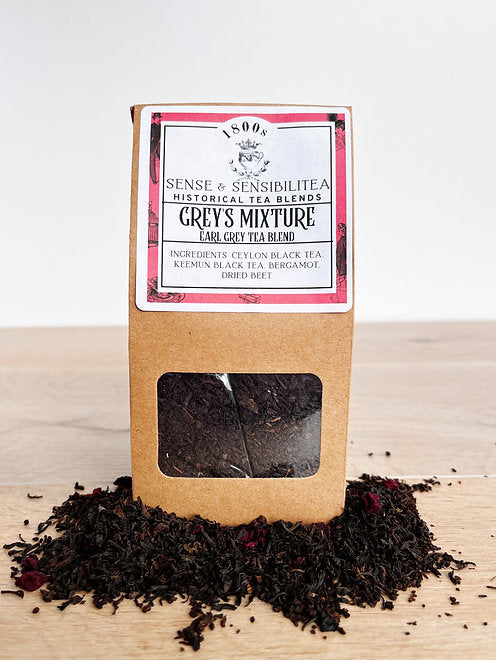 Grey's mixture tea blend package surrounded by tea leaves